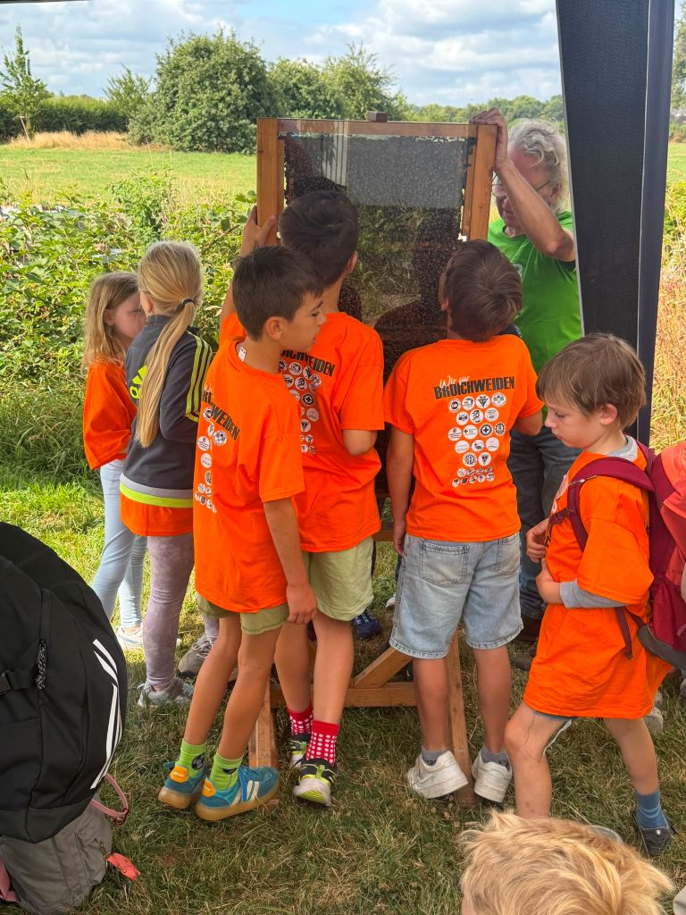 Kinder stehen um eine Betreuerin herum