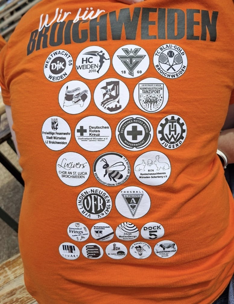 Ein T-Shirt mit den Abzeichen der beteiligten Gruppen